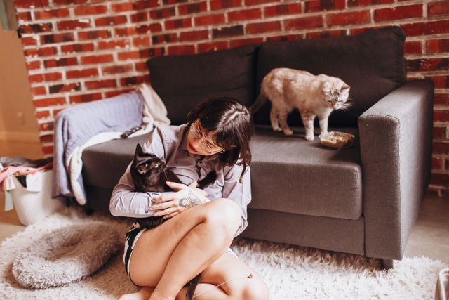 a person sitting in an apartment with cats